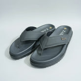 Gray sandals with 'Zara' branding on a wooden surface.